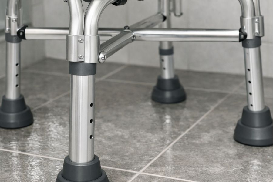 Detailansicht eines bariatrischen Duschstuhls mit verstärkten Beinen und breiten Gummifüßen
